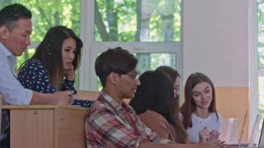 Grup arkadaşları konuşuyor, üniversitede dizüstü bilgisayar kullanıyorlar..