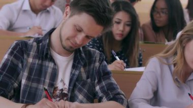 Üniversite sınıfında grup arkadaşları kitaplarda yazarlar.