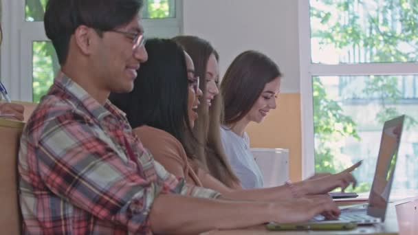 Grupos hablando, usando computadoras portátiles en la universidad . — Vídeos de Stock