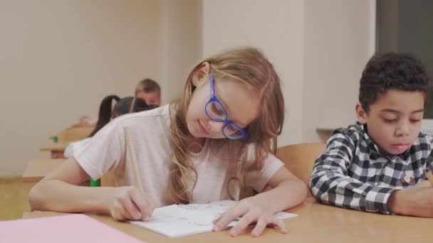 Dibujo de niña en copybook en el aula . — Vídeo de stock