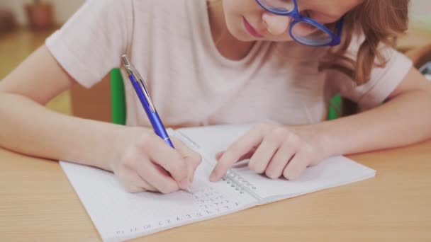 Bonita colegiala haciendo tareas de matemáticas . — Vídeo de stock