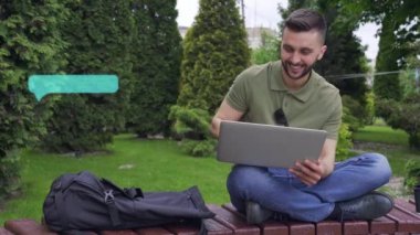 Gülümseyen adam dışarıda dizüstü bilgisayar kullanıyor..