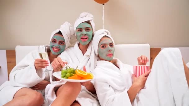 Amigos do sexo feminino fazendo festa na cama em roupões de banho . — Vídeo de Stock
