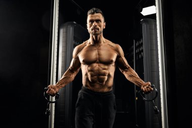 Muscular bodybuilder training on crossover.