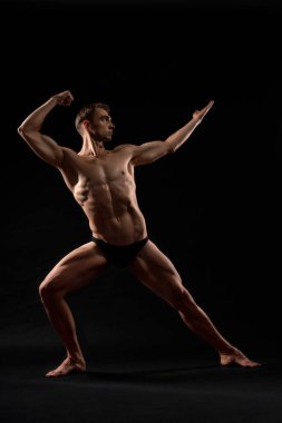 Male bodybuilder demonstrating contest pose.