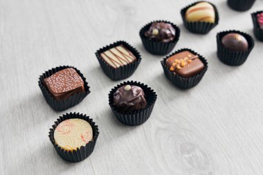 Different chocolate candies on wooden table.