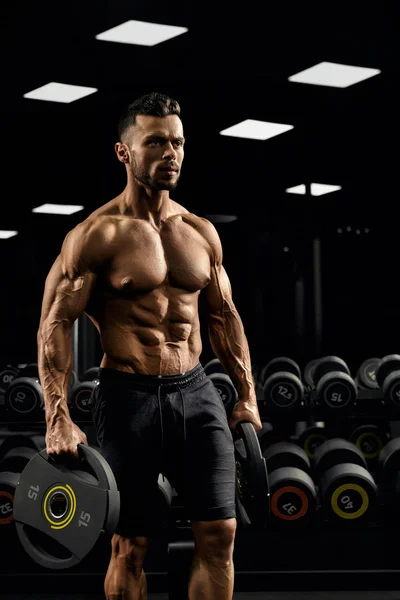 Tensed male bodybuilder holding weights. — Stock Photo, Image