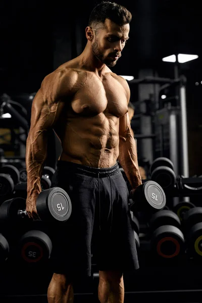 Shirtloze mannelijke bodybuilder met halters. — Stockfoto