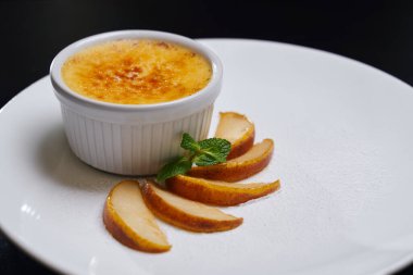 Küçük kâse ve armut diliminde cheesecake..