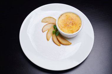 Küçük kâse ve armut diliminde cheesecake..