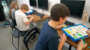 Çocuklar inşaat malzemesi kullanarak robot yapıyorlar..