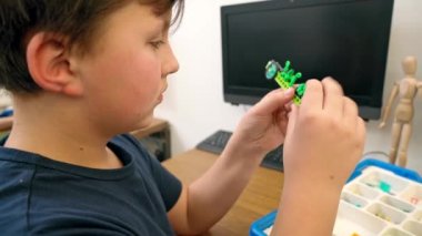 Çocuk inşaat malzemesi kullanarak robot yapıyor..