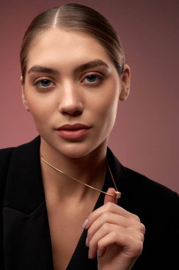 Altın kolye gösteren genç bir model..