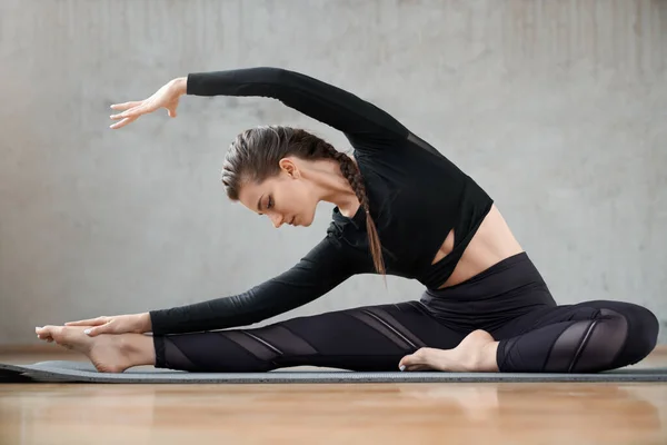 Adatto donna che pratica yoga lato flessione exrcise. — Foto Stock