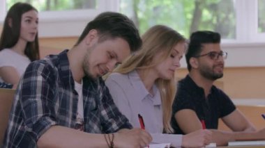Üniversitede grup arkadaşları konuşur, kitaplarda yazar..