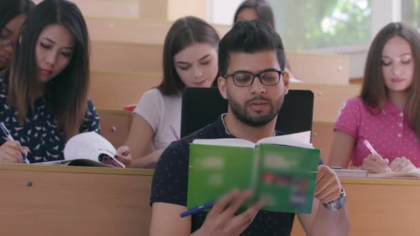 Estudiante masculino leyendo libro en clase . — Vídeo de stock