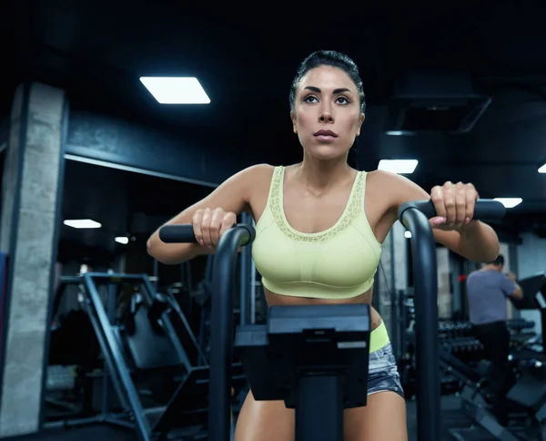 Fit mujer usando bicicleta estática en el gimnasio . — Foto de Stock