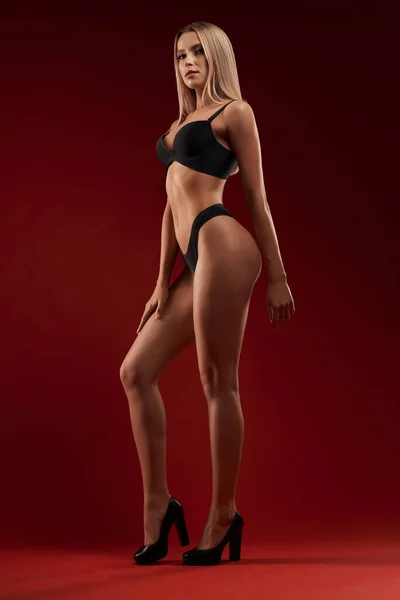 Sexy woman in lingerie isolated on red.