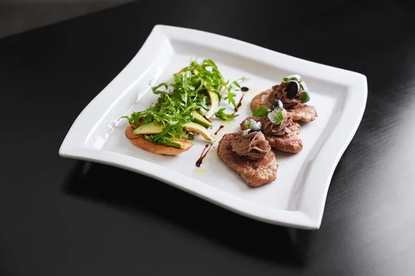 Beef steaks and toasts with avocado and rucola. — Stock Photo, Image