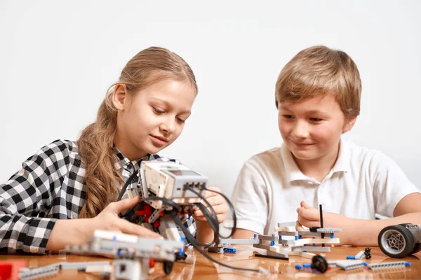 Jóvenes amigos creando robot usando kit de construcción. — Foto de Stock