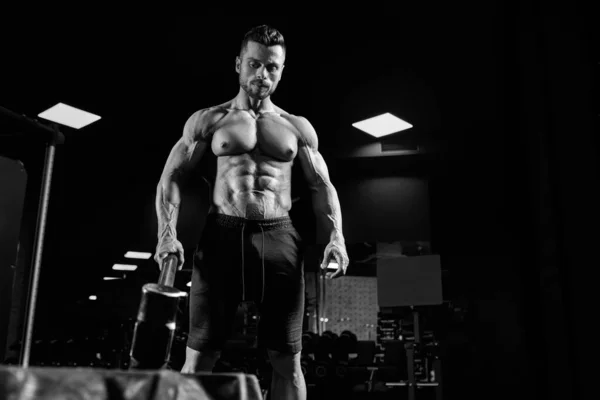 Musculoso hombre llevando mazo en el gimnasio. — Foto de Stock