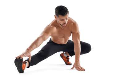 Gömleksiz kaslı adam bacaklarını açıyor..