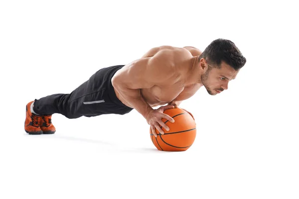 Muscular hombre haciendo flexiones usando baloncesto . — Foto de Stock