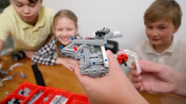 Niños felices ayudando a niño a crear juguete . — Vídeos de Stock