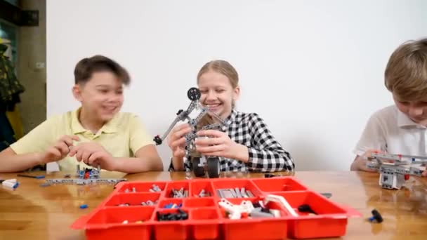 Jóvenes amigos divirtiéndose, usando kit de construcción. — Vídeo de stock