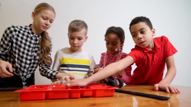 Anak-anak menggunakan peralatan bangunan untuk membuat mobil. — Stok Video