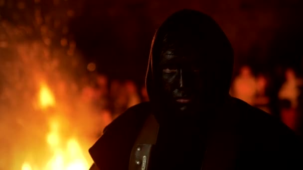 Homme au visage noir près du feu de joie ardent, festival . — Video