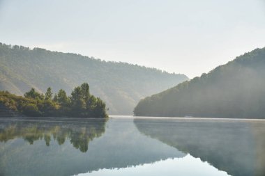 Nehir kıyısındaki dağlarda yaz sabahı.