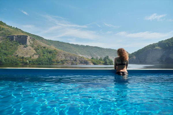 Mädchen im Pool bewundert Landschaft. — Stockfoto