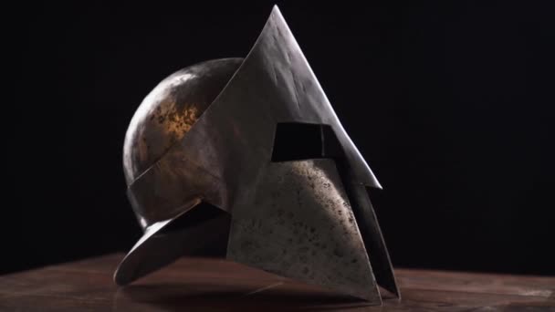 テーブルの上に古代の鉄のスパルタンヘルメット. — ストック動画