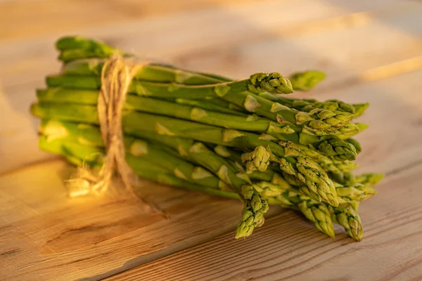 Ahşap bir masada yeşil kuşkonmaz