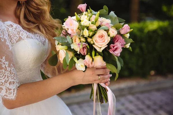 Krásné svatební kytice v rukou nevěsty. Část bílé šaty — Stock fotografie