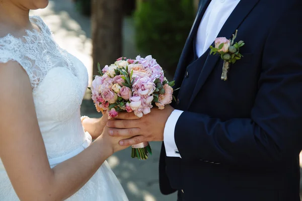 Brautstrauß in den Händen des Ehepaares — Stockfoto