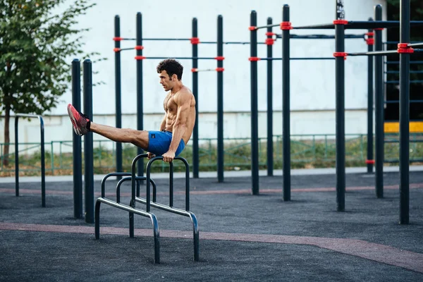 Homem muscular aquecendo antes do exercício no chão crossfit fazendo flexões como parte do treinamento. Conceito de desporto — Fotografia de Stock