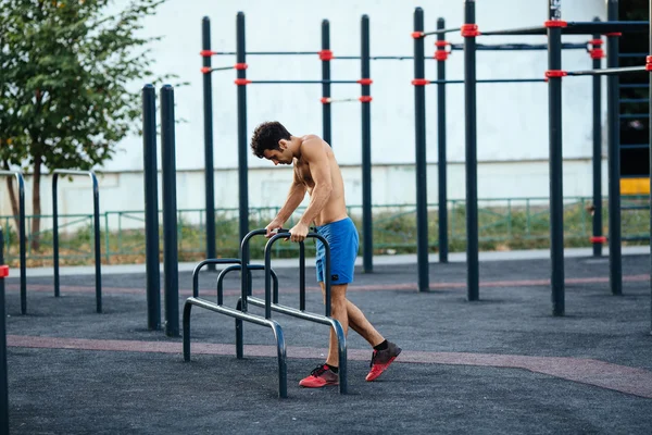 Muskulös man som uppvärmning innan träning på crossfit marken göra push ups som en del av utbildningen. Sport-konceptet — Stockfoto