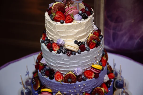 甘い連鎖ウェディング ケーキはフルーツで飾られました。ブルーベリー、イチゴ、ラズベリー。底に棒キャンディ — ストック写真