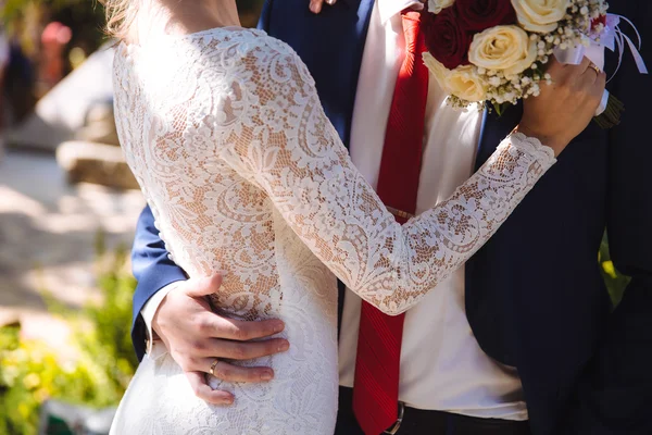 Braut und Bräutigam umarmen sich am Hochzeitstag. Konzept der Liebesfamilie — Stockfoto