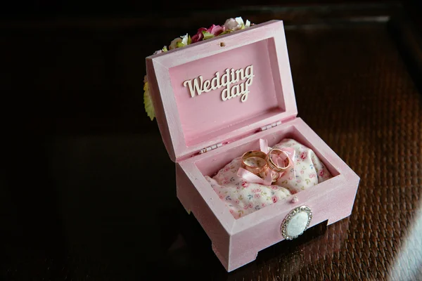 Два кільця в коробці з весільним днем напис на темному столі. Концепція шлюбу — стокове фото