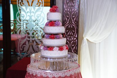 Tatlı çok düzeyli düğün pastası mavi çiçeklerle süslenmiş. Şeker çubuğu