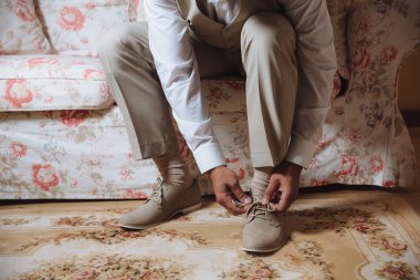 İş adamı klasik, şık ayakkabılar giyer. Damat düğün günü giyiniyor, bağcıkları bağlıyor ve hazırlanıyor..