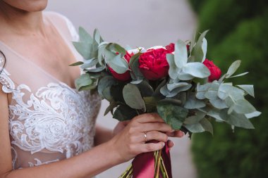 Güzel düğün buketi gelin elinde. Altın yüzük ve beyaz elbise