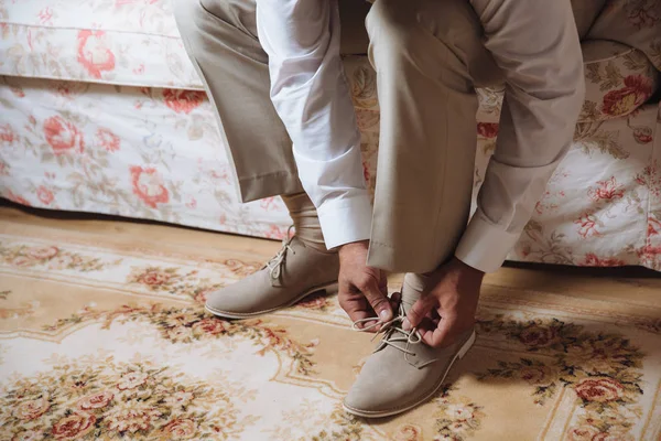 Business man dressing up with classic, elegant shoes. Groom wearing on wedding day, tying the laces and preparing.