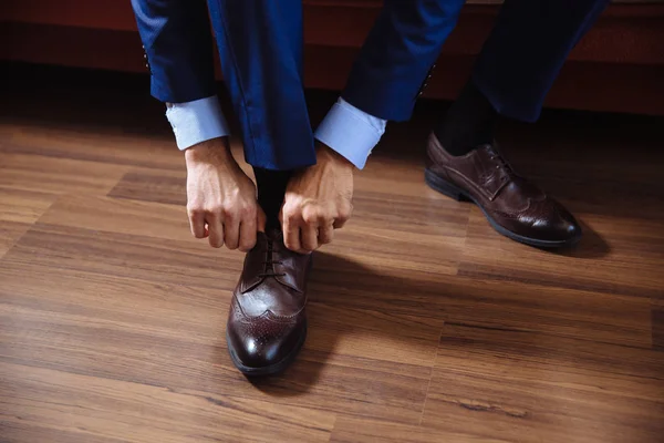 Hombre de negocios disfrazado con zapatos clásicos y elegantes. Vestido de novio el día de la boda, atar los cordones y preparar . —  Fotos de Stock