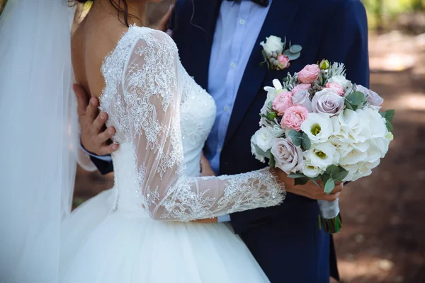 Brautstrauß in den Händen des Ehepaares — Stockfoto