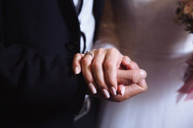 Alyans kahverengi masa üzerinde gelin ve damatlar elleriyle