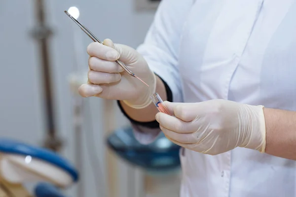 Médico dentista mão segurando ferramentas médicas em consultório odontológico. Conceito de saudável — Fotografia de Stock